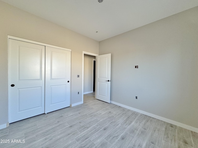 unfurnished bedroom with light hardwood / wood-style flooring and a closet