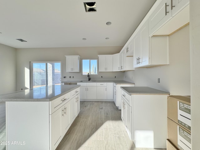 kitchen featuring a center island, sink, and white cabinets