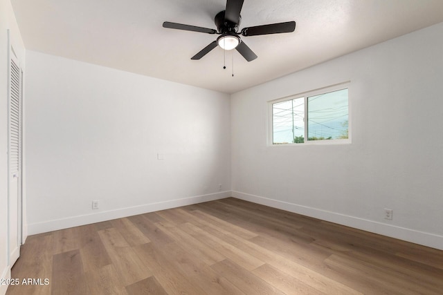 spare room with light wood-type flooring, ceiling fan, and baseboards