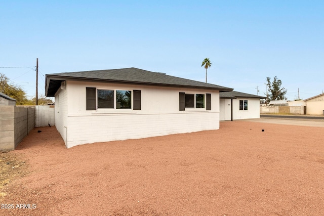 view of front of property featuring a shingled roof and fence