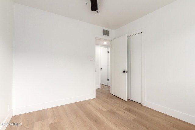 spare room featuring light wood-type flooring, baseboards, and visible vents