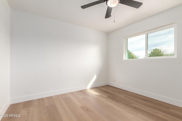 unfurnished room with a ceiling fan, light wood-style flooring, and baseboards