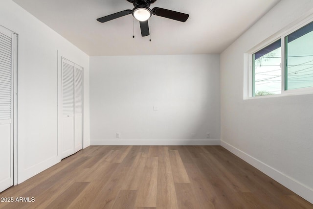 unfurnished bedroom featuring ceiling fan, light wood-type flooring, and baseboards