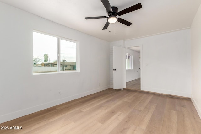 unfurnished room featuring a healthy amount of sunlight, light wood-style flooring, and baseboards