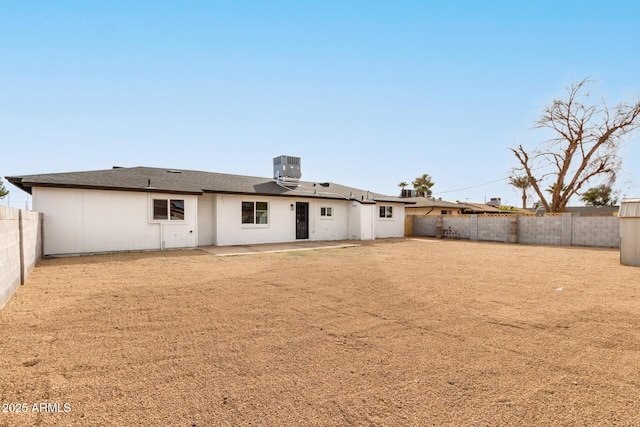 back of house with a fenced backyard, a patio, and central AC