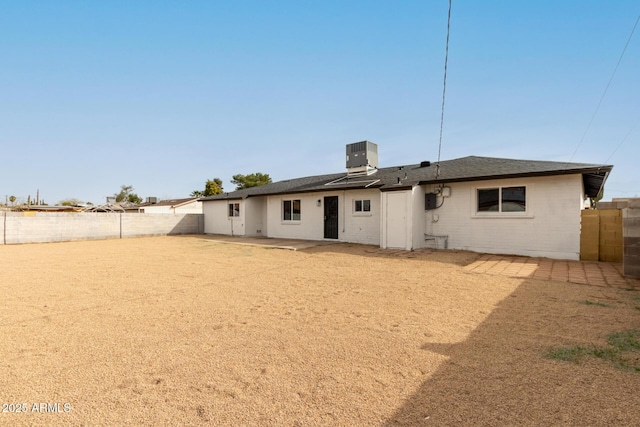 back of property with a patio area, a fenced backyard, central AC unit, and brick siding