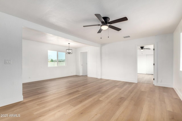 spare room featuring visible vents, light wood-style flooring, and baseboards