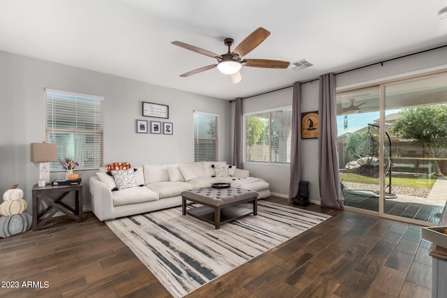 living room with ceiling fan and dark wood-type flooring