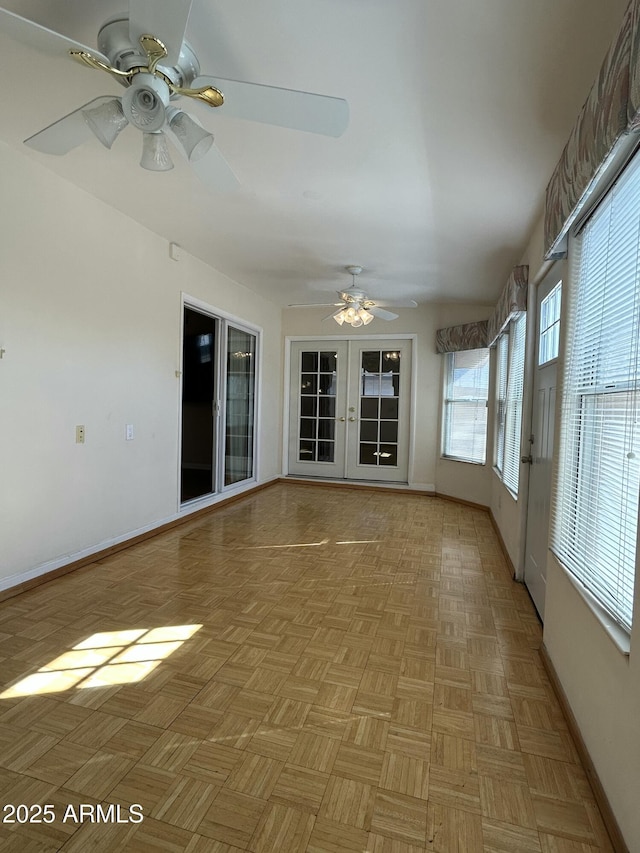 unfurnished sunroom with ceiling fan