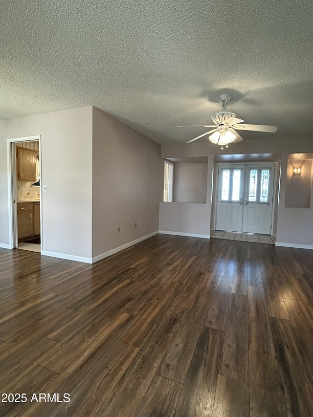 empty room featuring ceiling fan, dark hardwood / wood-style flooring, and a textured ceiling