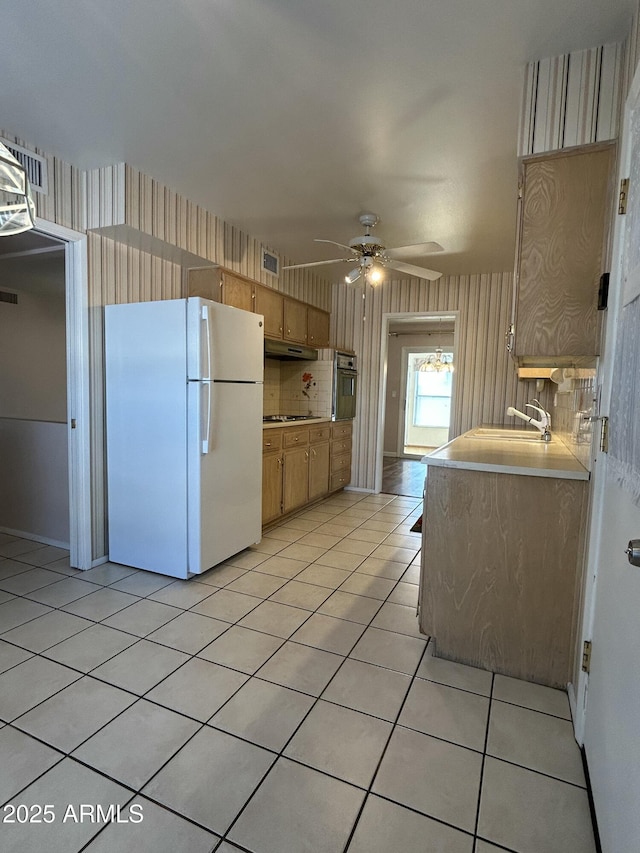 kitchen featuring light brown cabinetry, sink, light tile patterned floors, ceiling fan, and black appliances