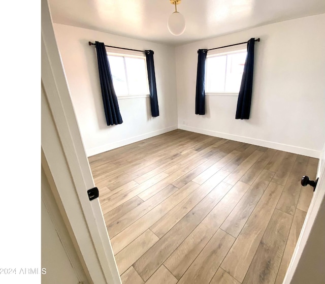 unfurnished room featuring light hardwood / wood-style flooring and a wealth of natural light