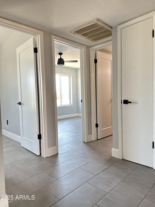 5924 W Tierra Buena Ln, Glendale, AZ 85306 - corridor featuring a textured ceiling, light tile patterned flooring, and baseboards