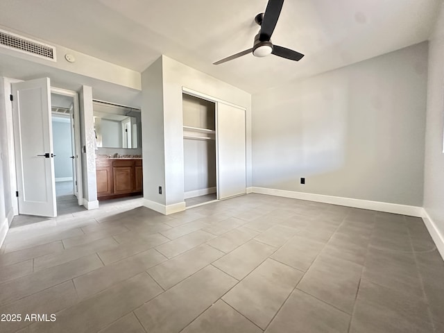 5924 W Tierra Buena Ln, Glendale, AZ 85306 - unfurnished bedroom featuring a closet, baseboards, tile patterned flooring, a ceiling fan, and ensuite bath