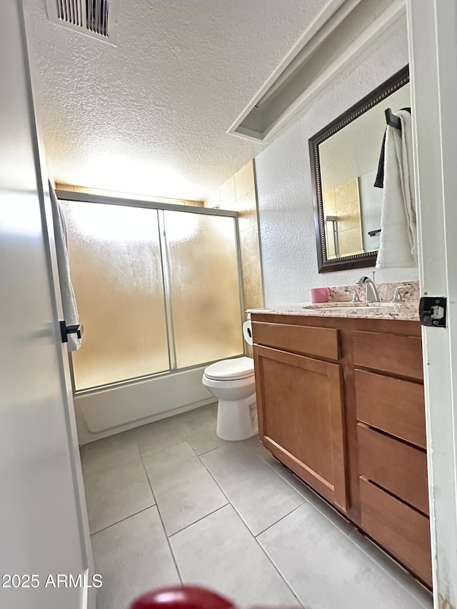 5924 W Tierra Buena Ln, Glendale, AZ 85306 - bathroom with a textured ceiling, tile patterned floors, bath / shower combo with glass door, toilet, and vanity