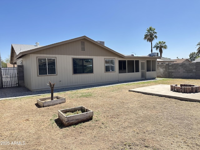 5924 W Tierra Buena Ln, Glendale, AZ 85306 - back of house featuring a fire pit, a sunroom, a patio area, and a gate