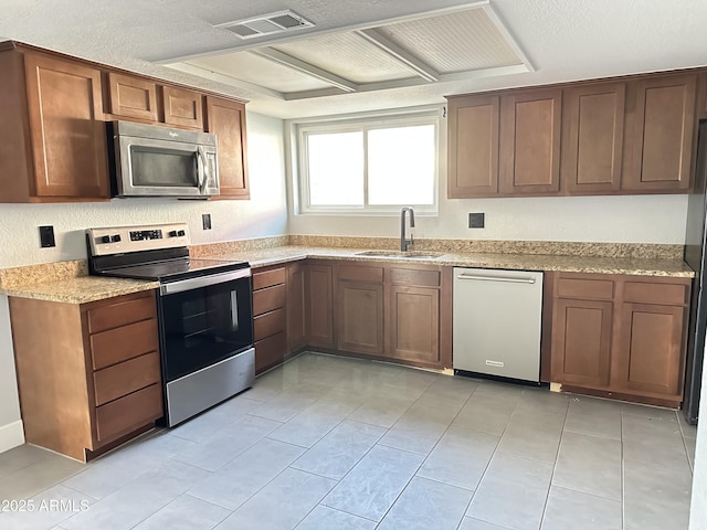 5924 W Tierra Buena Ln, Glendale, AZ 85306 - kitchen featuring appliances with stainless steel finishes, a sink, light stone countertops, and light tile patterned floors