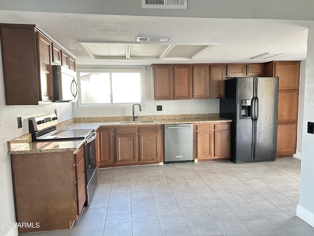 5924 W Tierra Buena Ln, Glendale, AZ 85306 - kitchen featuring appliances with stainless steel finishes, a sink, a textured ceiling, light stone counters, and light tile patterned floors