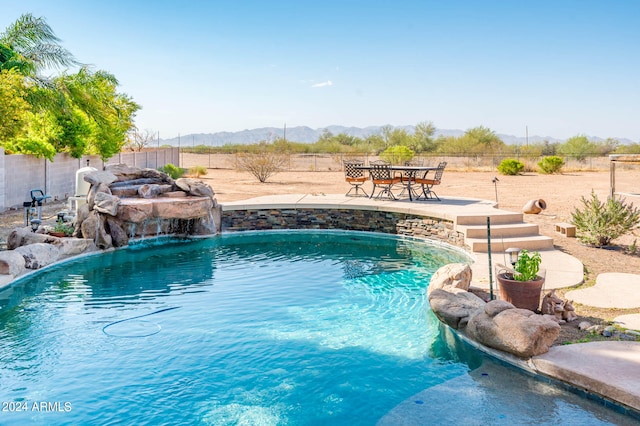 view of swimming pool with a mountain view, a patio, and pool water feature