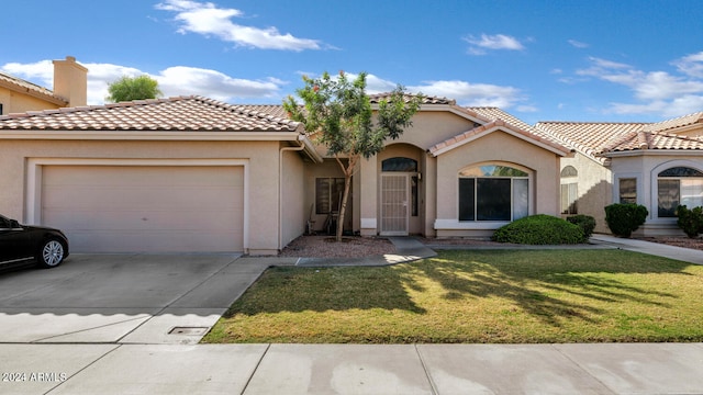 mediterranean / spanish home featuring a tile roof, stucco siding, concrete driveway, an attached garage, and a front lawn