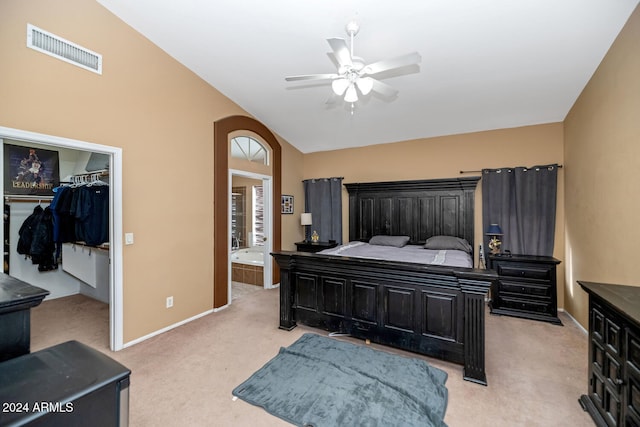 bedroom featuring lofted ceiling, light carpet, ceiling fan, a closet, and a walk in closet