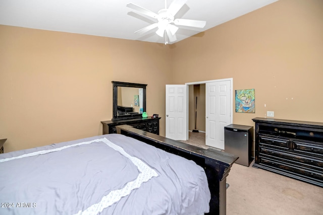 bedroom with ceiling fan, stainless steel fridge, and light colored carpet