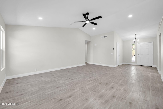 unfurnished living room featuring ceiling fan with notable chandelier, light wood-type flooring, and lofted ceiling