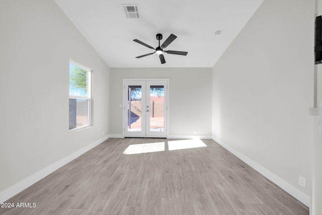 empty room featuring ceiling fan, french doors, light hardwood / wood-style floors, and vaulted ceiling