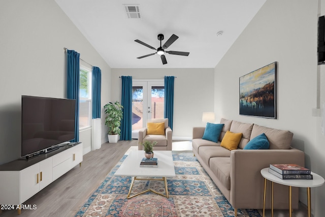 living room featuring french doors, light wood-type flooring, vaulted ceiling, and ceiling fan