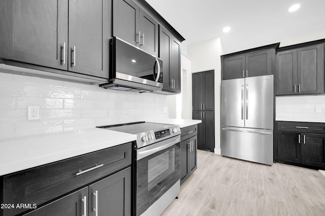 kitchen featuring decorative backsplash, light hardwood / wood-style floors, and appliances with stainless steel finishes