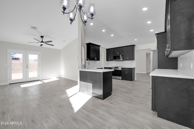 kitchen featuring sink, stainless steel appliances, light hardwood / wood-style flooring, vaulted ceiling, and ceiling fan with notable chandelier