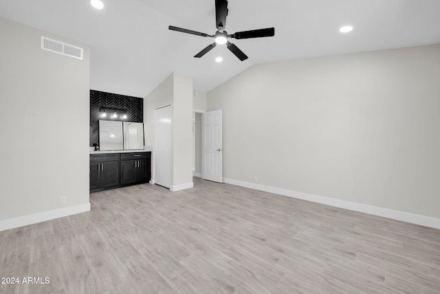 unfurnished living room with ceiling fan, lofted ceiling, and light wood-type flooring