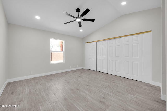 unfurnished bedroom featuring ceiling fan, a closet, light hardwood / wood-style floors, and lofted ceiling