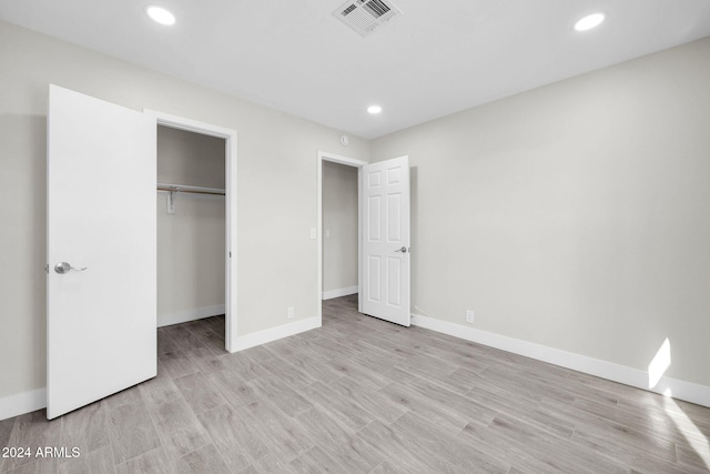 unfurnished bedroom featuring a closet and light hardwood / wood-style flooring