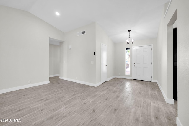 foyer entrance with a chandelier, light hardwood / wood-style floors, and vaulted ceiling