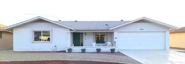 ranch-style house featuring a garage, concrete driveway, brick siding, and a porch