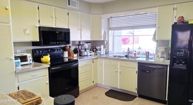 kitchen with a toaster, a sink, visible vents, light countertops, and black appliances