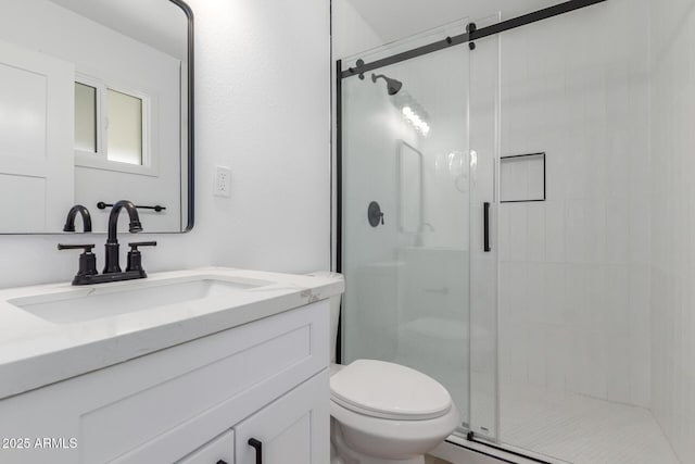 bathroom featuring vanity, a shower stall, and toilet