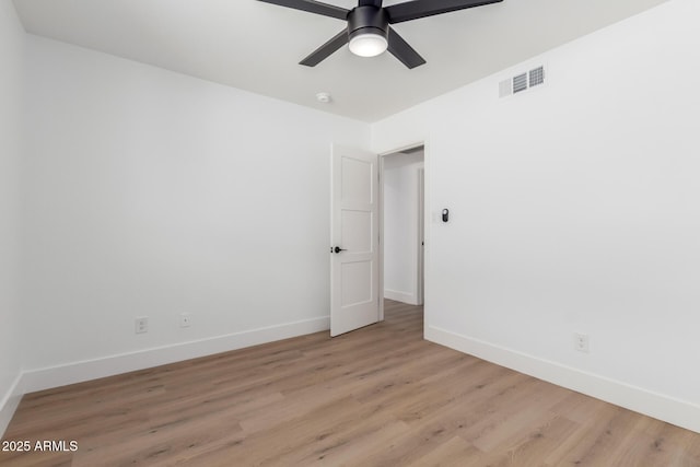 spare room featuring visible vents, a ceiling fan, light wood-style flooring, and baseboards
