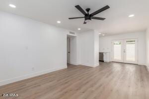 unfurnished living room with wood finished floors, baseboards, ceiling fan, recessed lighting, and french doors