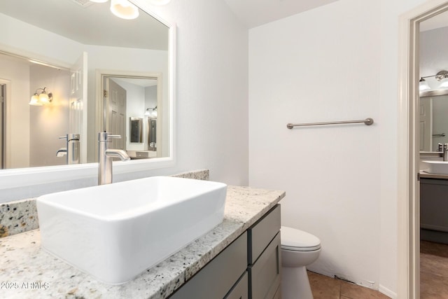 bathroom featuring vanity, toilet, and tile patterned flooring