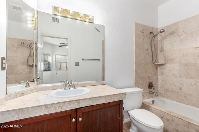 full bathroom with vanity, ceiling fan, toilet, and tiled shower / bath