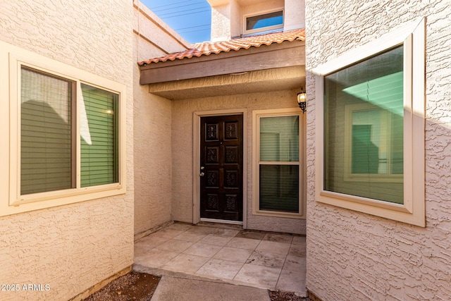 view of exterior entry with a patio area