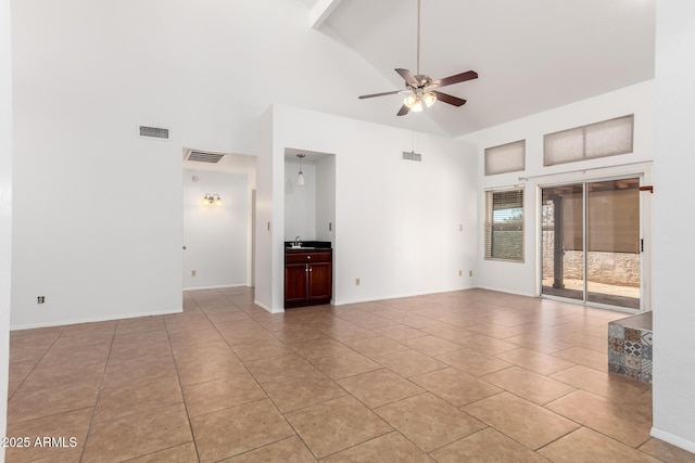 tiled empty room with high vaulted ceiling, sink, and ceiling fan