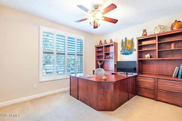 carpeted home office featuring ceiling fan