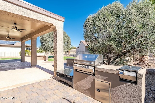 view of patio featuring grilling area, ceiling fan, and exterior kitchen