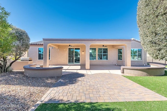 rear view of property with ceiling fan and a patio