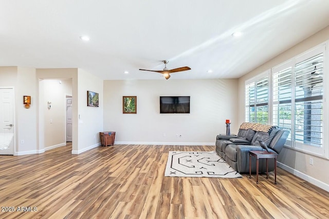 living room with ceiling fan and light wood-type flooring