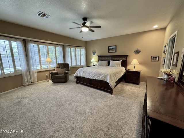 carpeted bedroom with a textured ceiling and ceiling fan