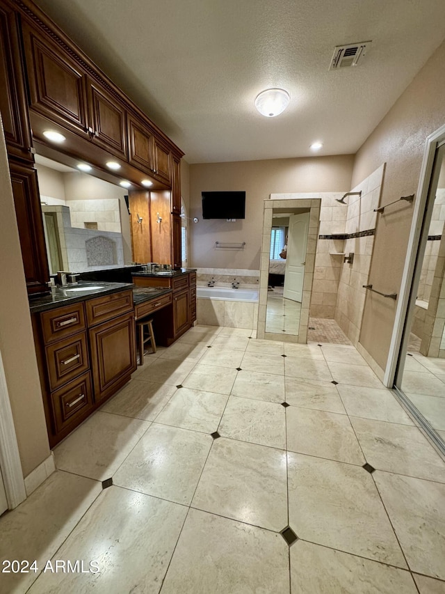 bathroom featuring a textured ceiling, vanity, separate shower and tub, and tile patterned floors